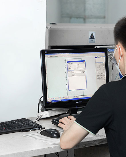 a worker operate the laser cutting machine via computer